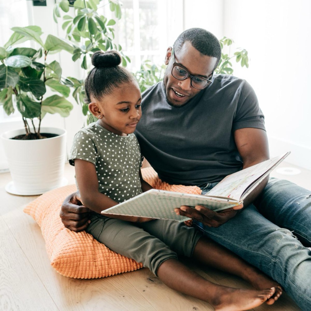 A father and daughter sharing a picture book